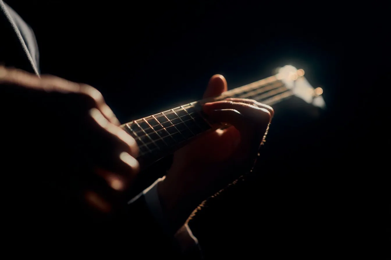 Close-up of a left hand fretting an Irish tenor banjo