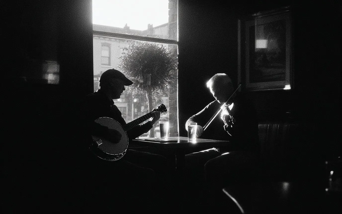 Two musicians playing banjo and fiddle at a pub table by a window